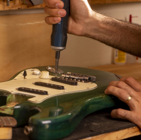 luthier-working-repairing-guitar