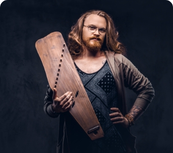 redhead-hipster-male-with-long-luxuriant-hair-full-beard-dressed-casual-clothes-holds-russian-traditional-musical-instrument-gusli-isolated-dark-background